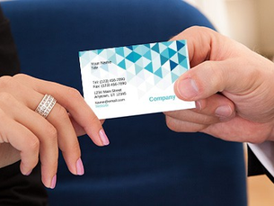 A professional handing out a business card to connect with client at a networking event.