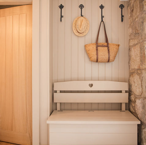 utility space with washing machine and tumble dryer and a boot room to hang coats and store shoes and boots