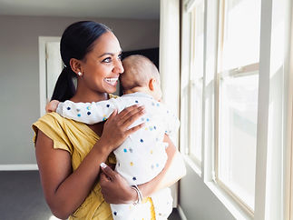 Sleep trainer, postpartum doula, and newborn care specialist holding infant