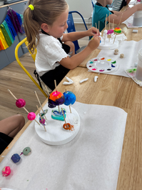 Mini Makers used air-dry clay to create small beads and shapes to build a stacked totem sculpture.