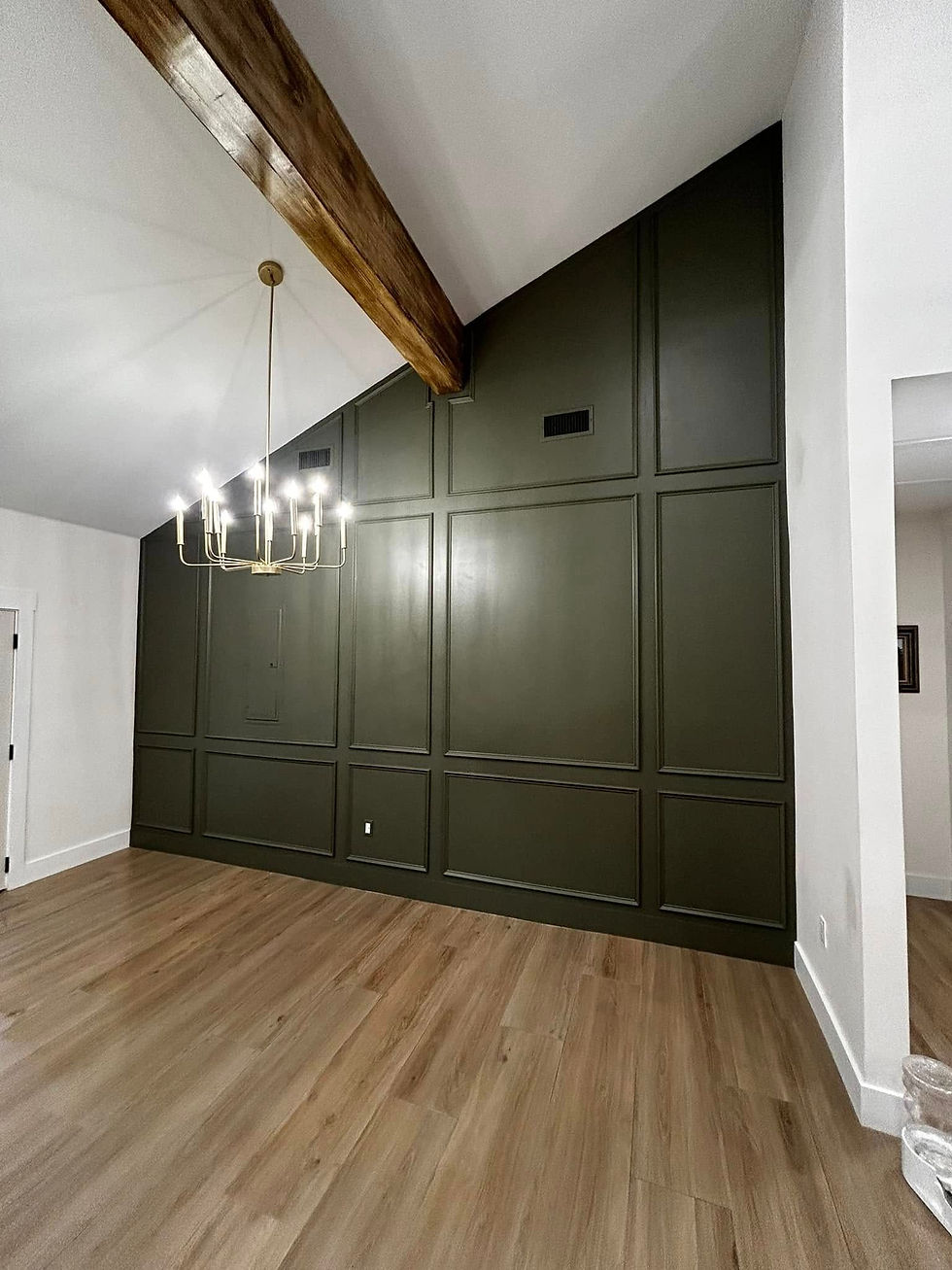 Living room with green built-in cabinets, exposed beam and wood floors