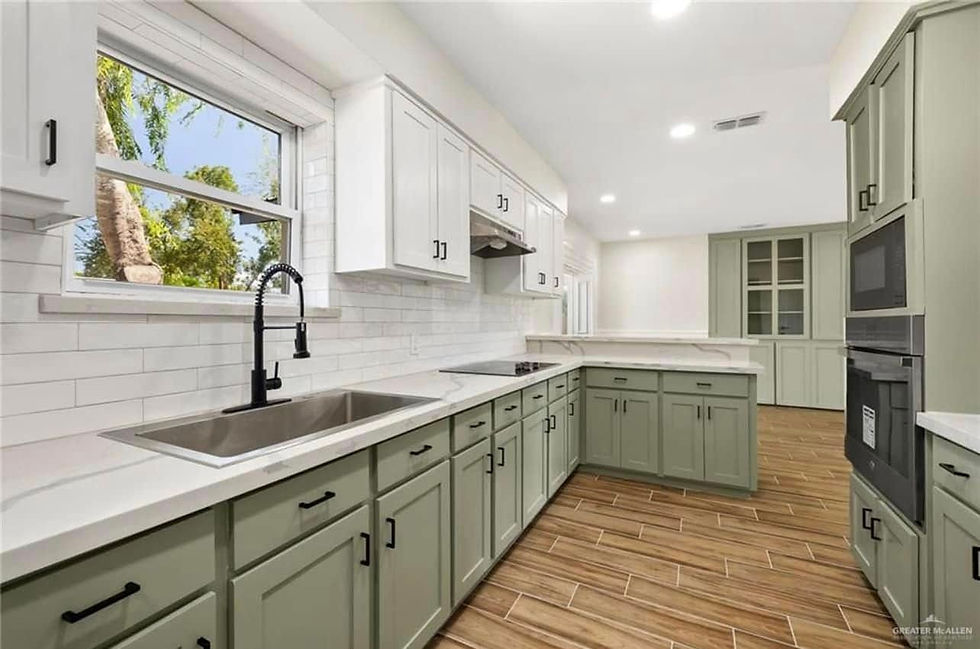 Kitchen with sage-green cabinets, white counters and wood floors