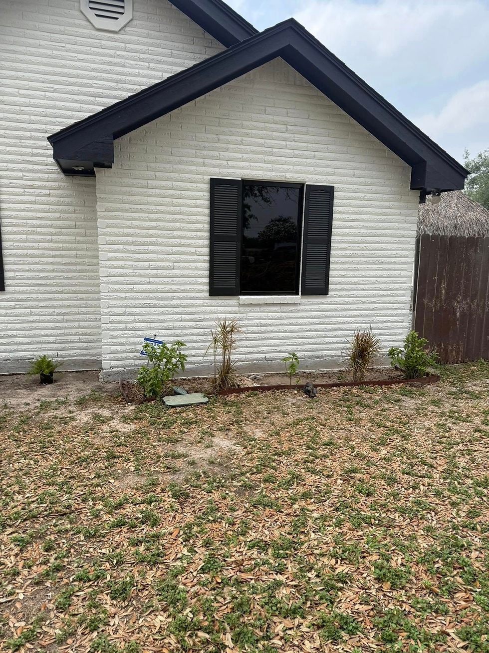 White brick home exterior with dark trim and black shutters