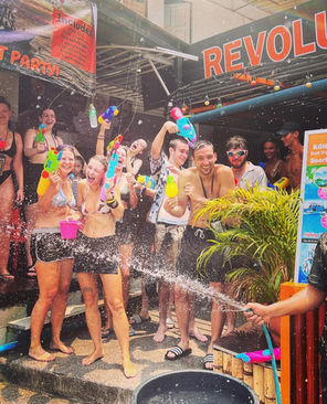 Group of people out the front of Revolution Hostel Koh Tao with waterguns, celebrating Songkran 2023