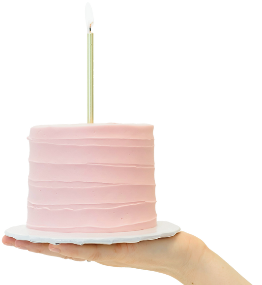 small pink cake with lit candle