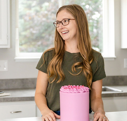 smiling woman holding a pink cake