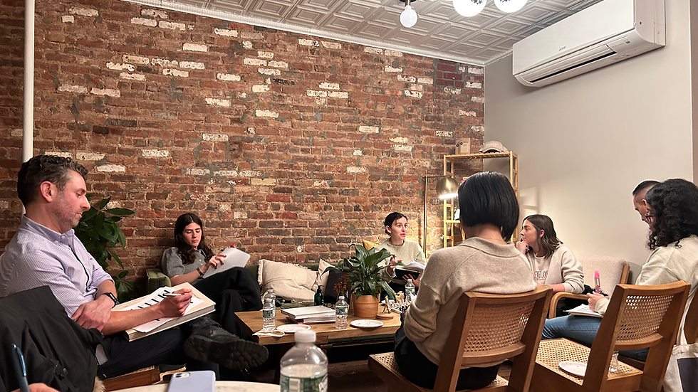 GEM Treasure Chest members in a small group coaching session, seated in a cozy room with notebooks, discussing personal and professional growth goals.