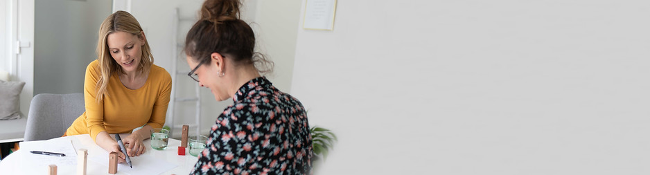 Gina Friedrich mit Kundin am Tisch bei der Aufstellungsarbeit im Coaching