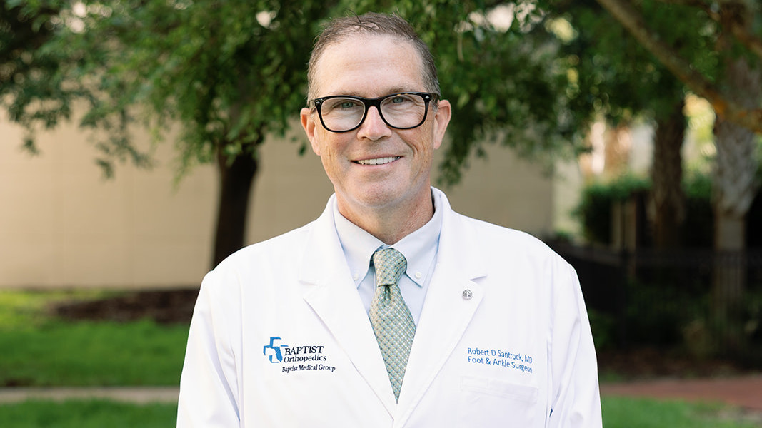 Dr. Santrock, co-inventor of Lapiplasty standing outside his clinic, BONe.