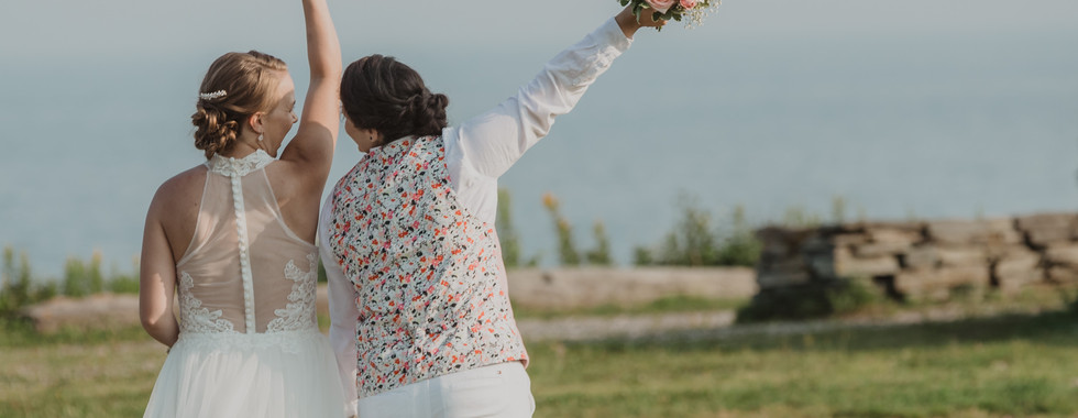 LGBT couple holding flowers during Maine elopement photoshoot
