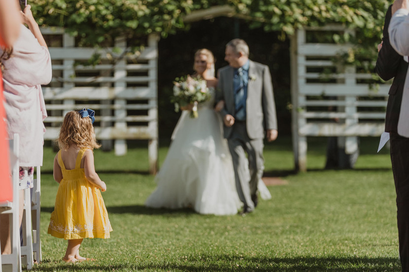 Little girl watching bride walk down the aisle at watertown wedding