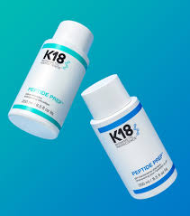Two K18 PEPTIDE PREP shampoo bottles (detox and maintenance) floating against a blue gradient background. Image used in the DCHAN SALON blog post.