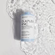 OLAPLEX Nº4C Clarifying Shampoo lying in shallow water, capturing its clean and refreshing essence. Highlighted in the DCHAN SALON blog post