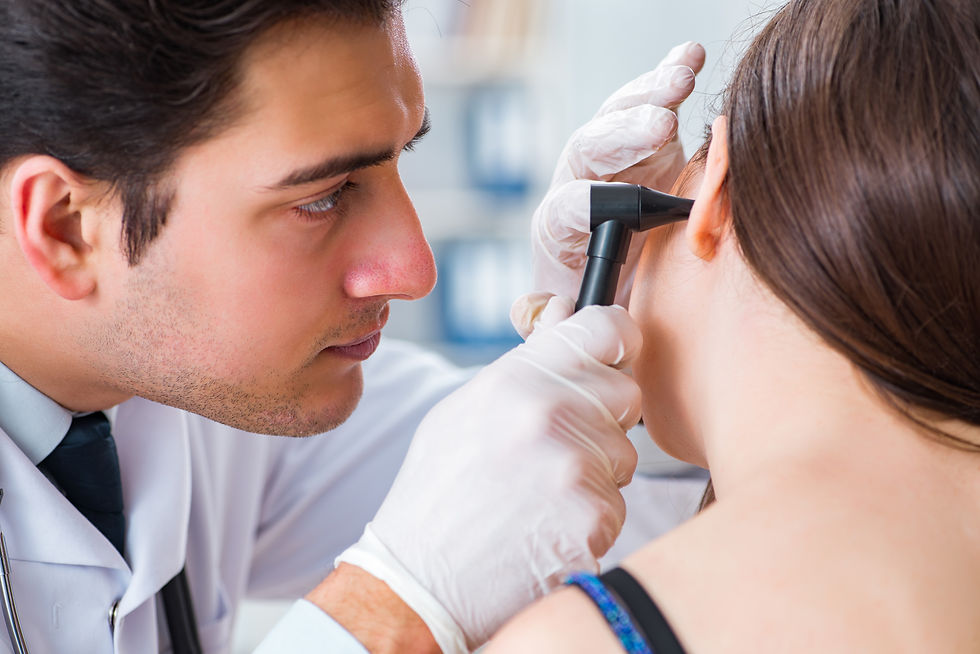 Practioner examines patient's ears - MK Ear Wax Clinic