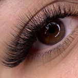 Nahaufnahme eines Auges mit Wimpernverlängerung, braune Iris, Schönheit.