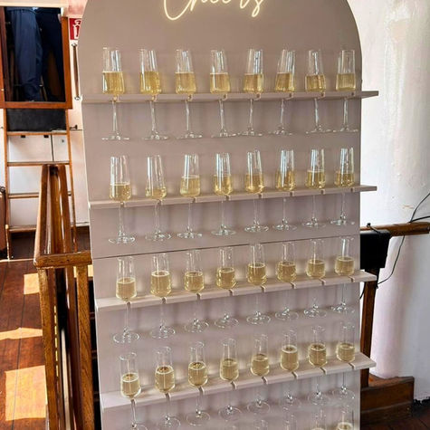Moderne Sektwand mit LED-Schriftzug „Cheers“ und stilvoll arrangierten Sektgläsern – perfektes Highlight für Hochzeit, Empfang oder exklusives Event.