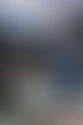 Groom posing against canmore train bridge