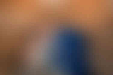 bride and groom kissing while cutting wedding cake