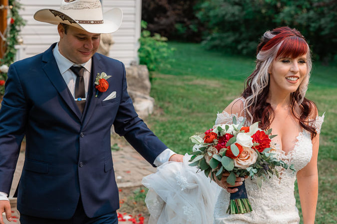 Groom helping bride with dress while walking