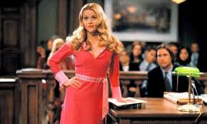 Elle Woods from Legally Blonde, standing in a courtroom, in a bright pink dress