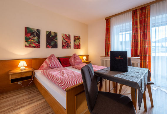 Doppelzimmer mit Doppelbett und Tisch mit 2 Stühlen