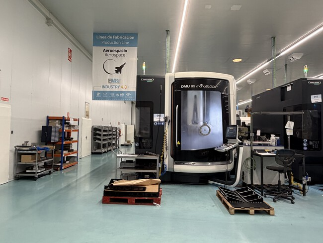 El salto a la "Industria 4.0". Una de las imponentes máquinas de mecanizado bajo un cartel de la línea de producción aeroespacial. La integración bajo un mismo techo permite a la empresa un control total sobre la calidad y los plazos. Imagen: Xataka.