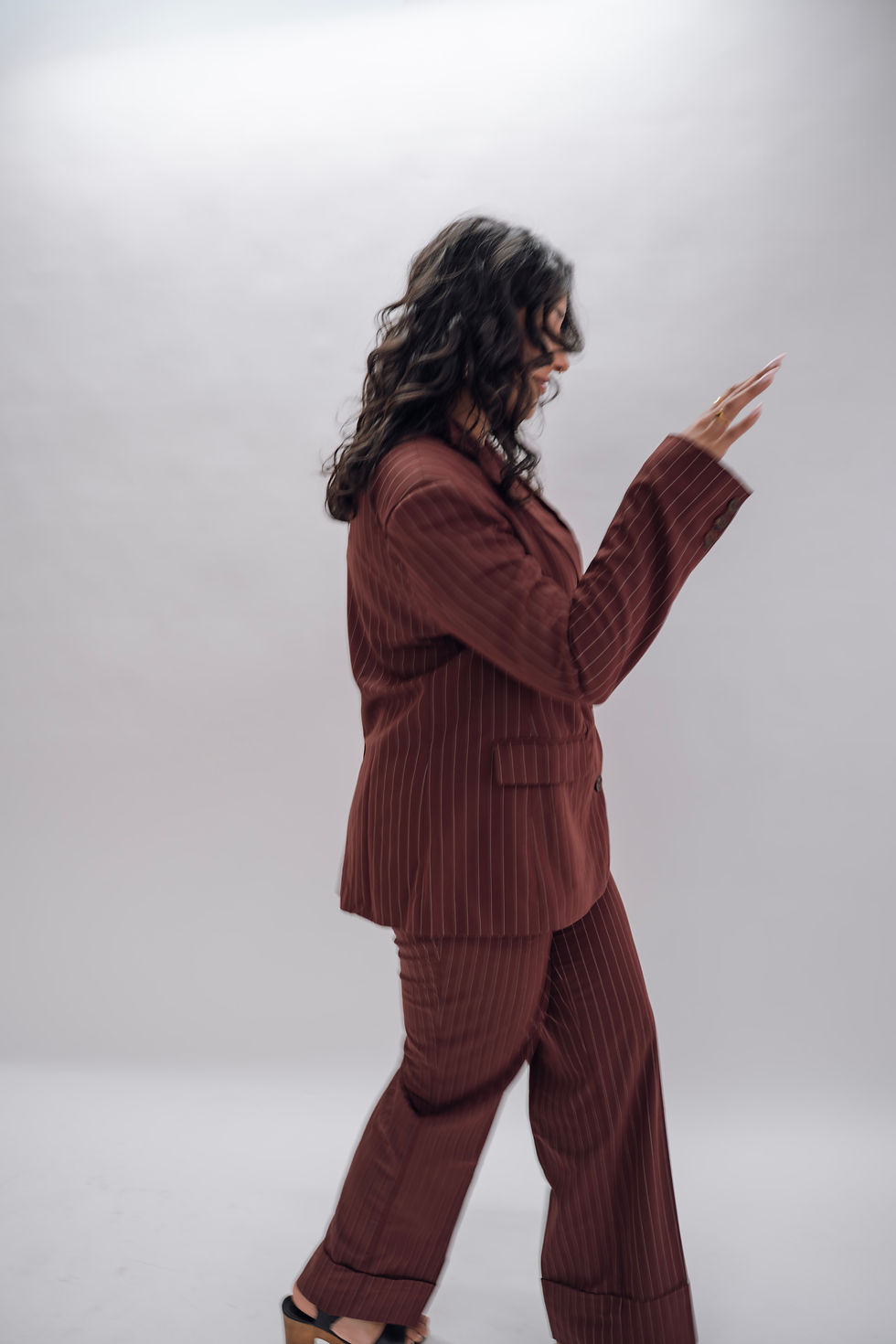 Prab Rai posing in a maroon suit against a plain background