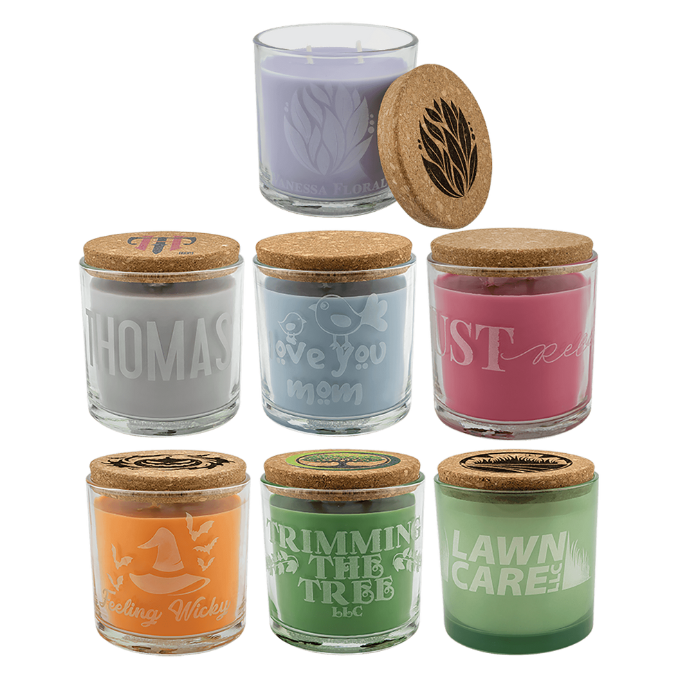 A collection of seven clear glass candles with natural cork lids featuring different colored wax options and scents.