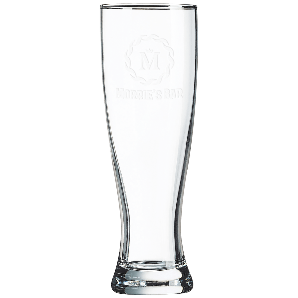 Frosted 'Aurora Pils' logo engraving on an empty, clear pilsner beer glass isolated on a black background.
