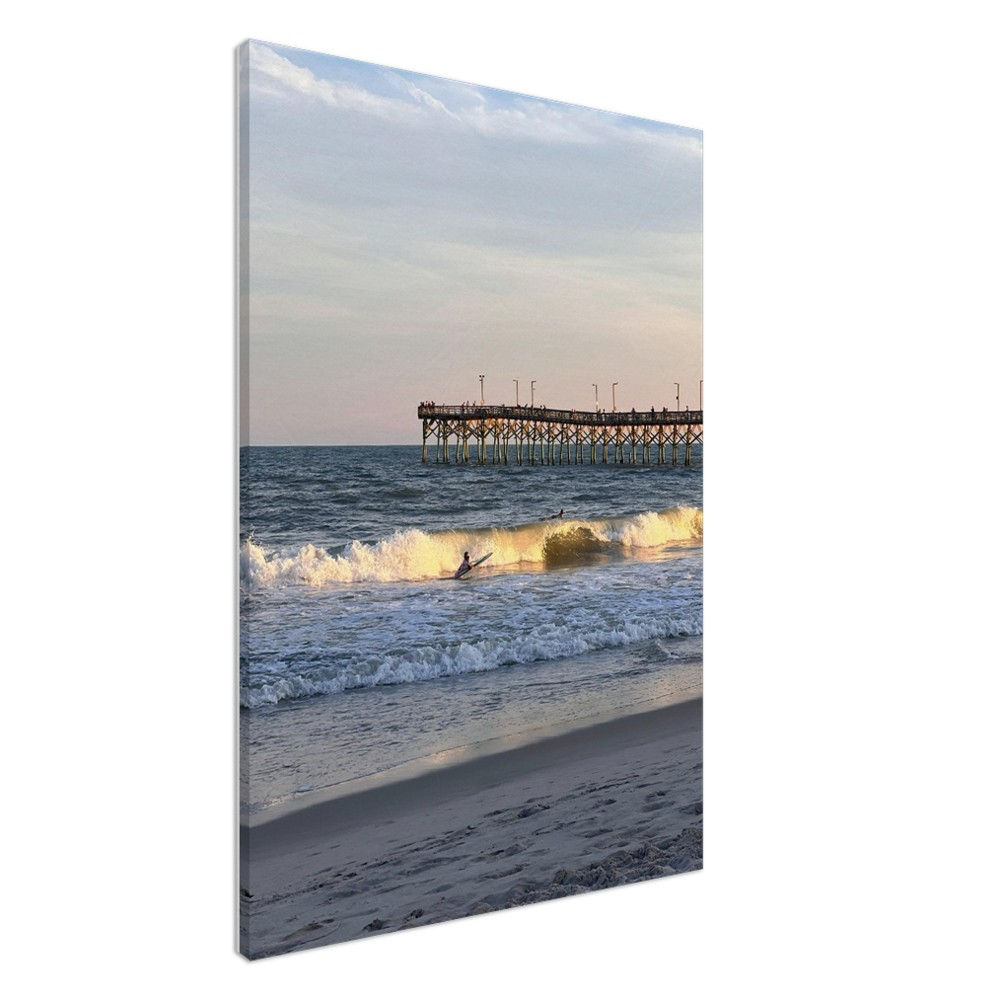 Surfing at sunset by the pier NC beach
