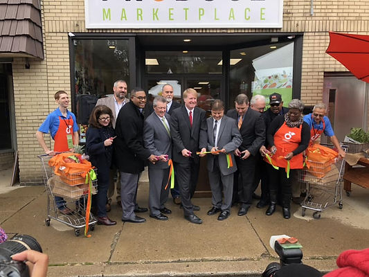 Just Harvest ribbon cutting celebration group photo with Just Harvest workers and men in suits