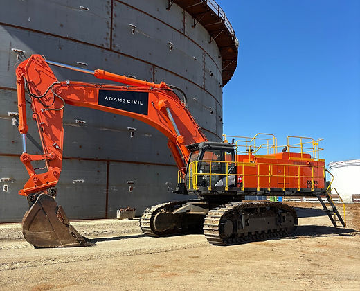 Adams Civil excavator working beside a fuel tank