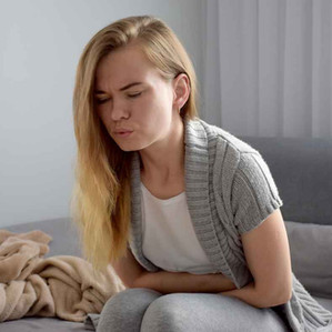 Frau mit Völlegefühl und Blähbauch hält sich den Bauch