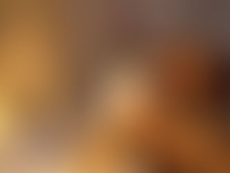 Frau sitzt abends erschöpft auf dem Bett und umarmt eine Decke in warmem Licht.