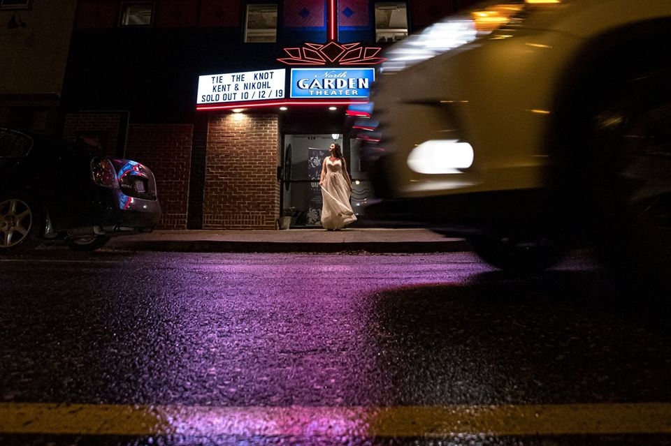 Bride in front of the wet pavement.