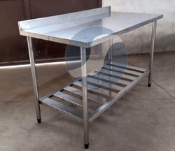Mesa em aço inox com espelho e prateleira gradeada.