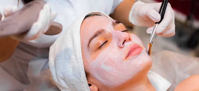 mascarilla facial en rostro de mujer aplicao con brocha