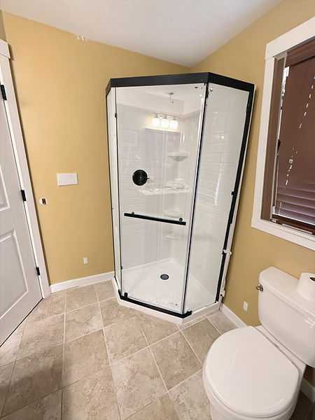 new shower with beautiful glass shower surround in black trim and delta shower valve