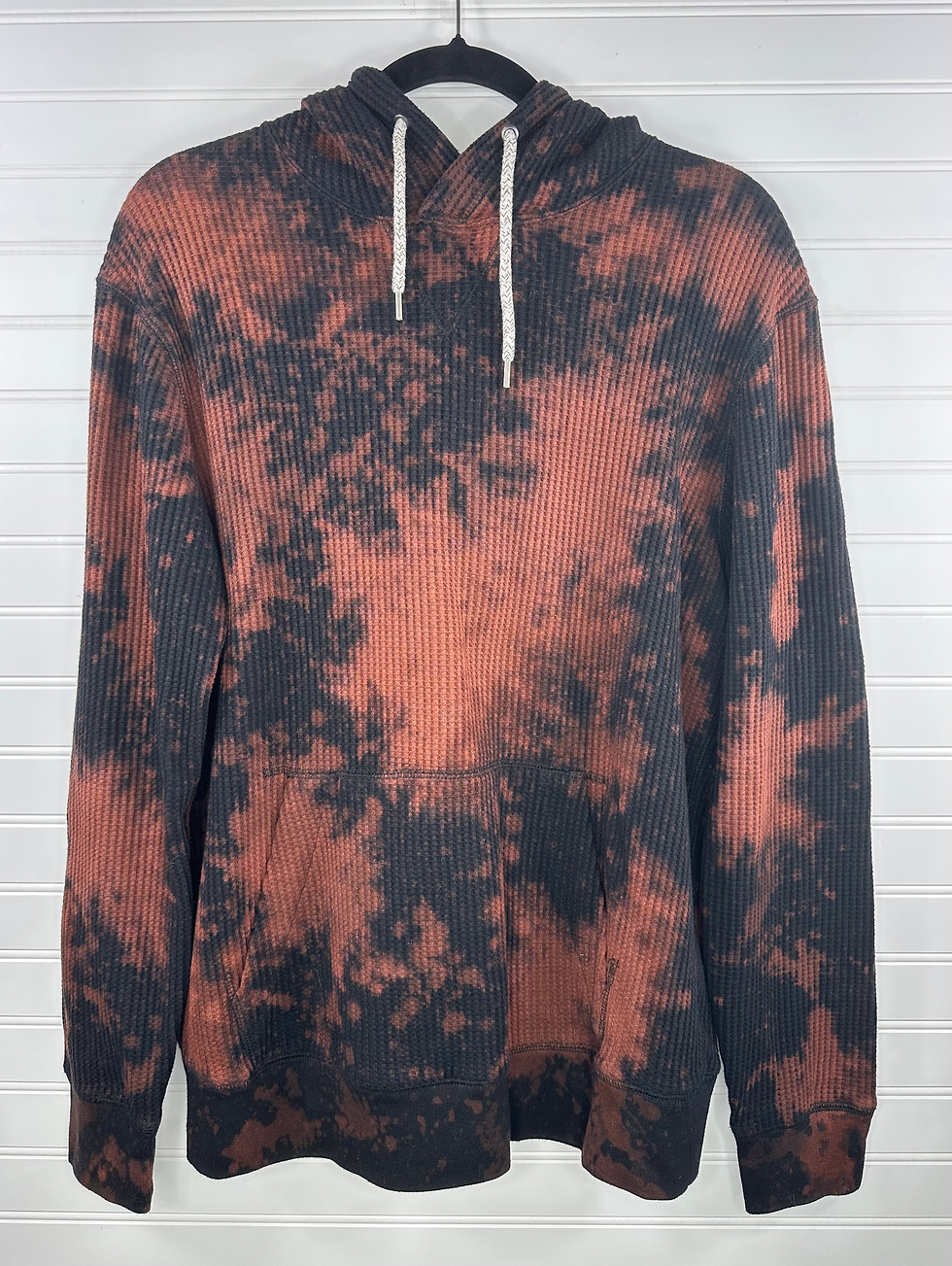 Ribbed black hoodie with orangish bleach splatter, no graphic 