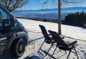 Stellplatz im Schnee mit sonniger Aussicht auf die Berge