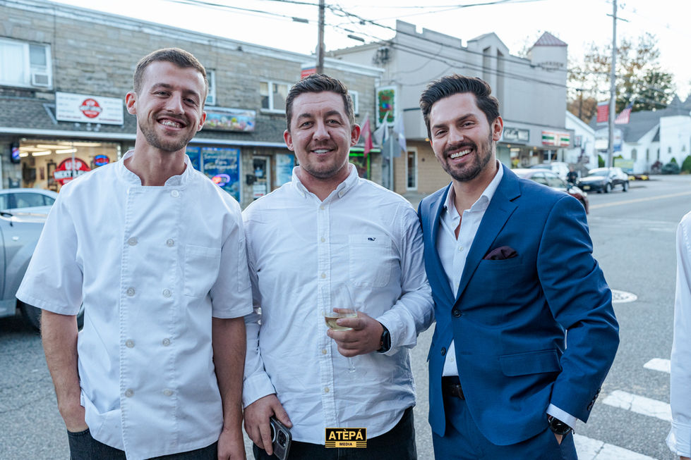 three men are posing for a picture with a sign that says atepa