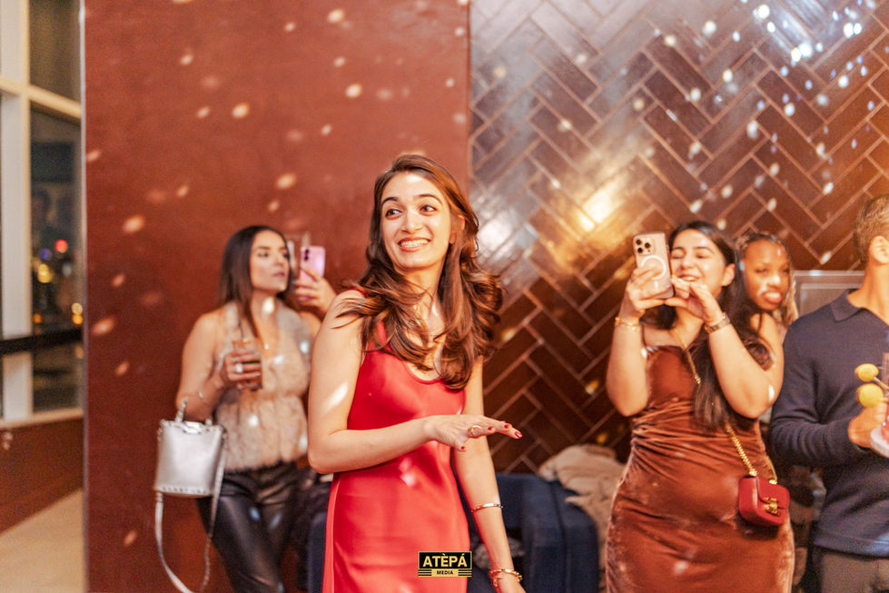 a woman in a red dress stands in front of a wall that says atepa
