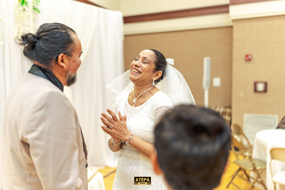 a woman in a wedding dress laughs while standing next to a man in a suit
