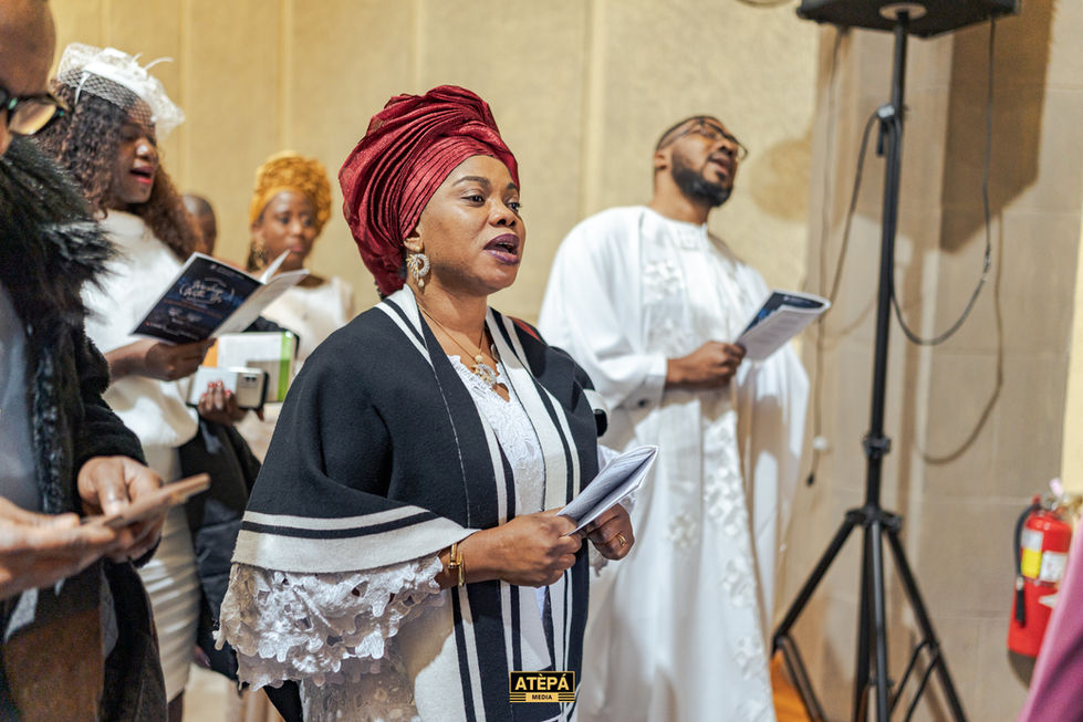 a woman singing in front of a sign that says atepa