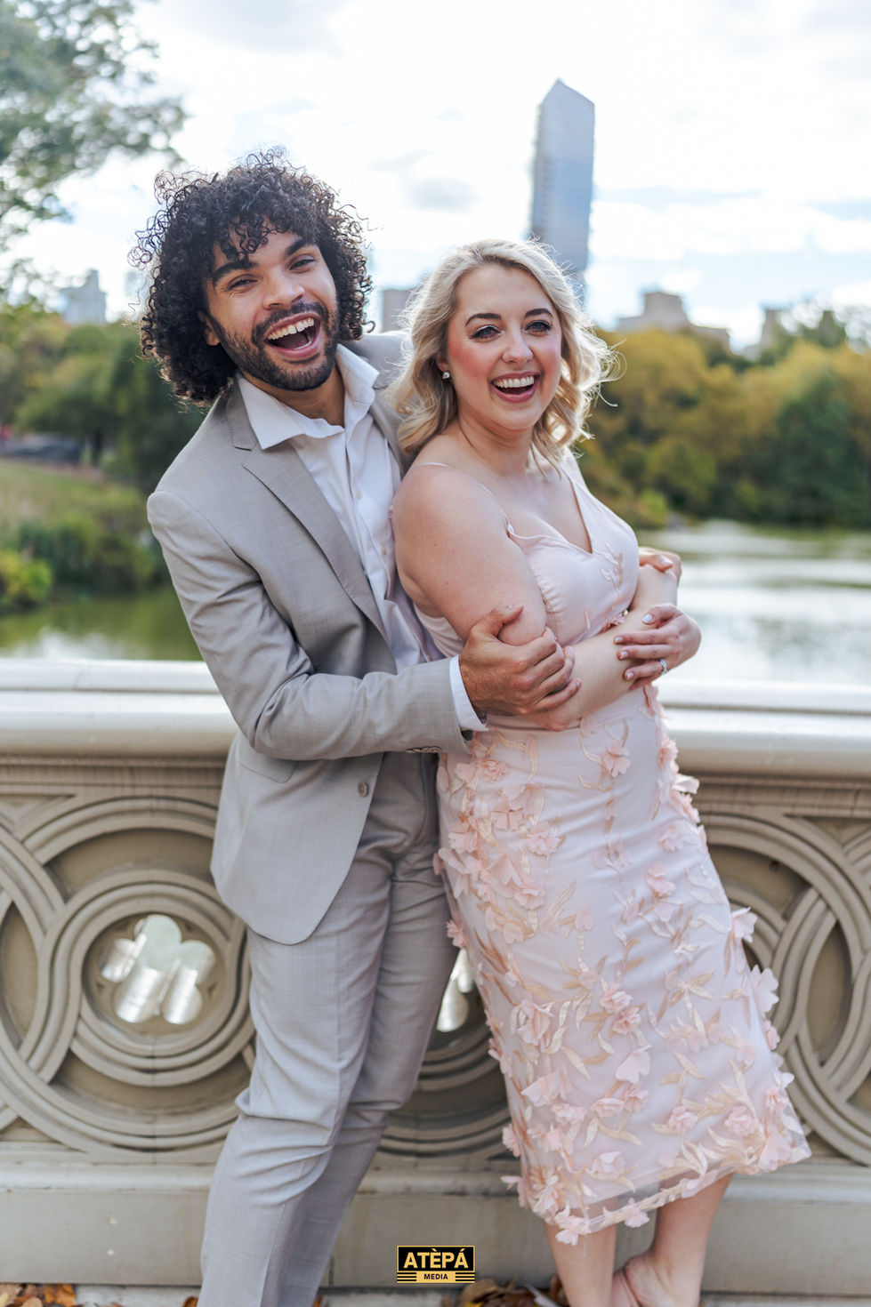 a man in a suit is hugging a woman in a pink dress