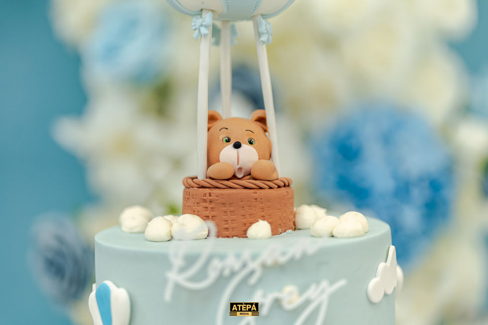 a blue cake with a teddy bear in a hot air balloon