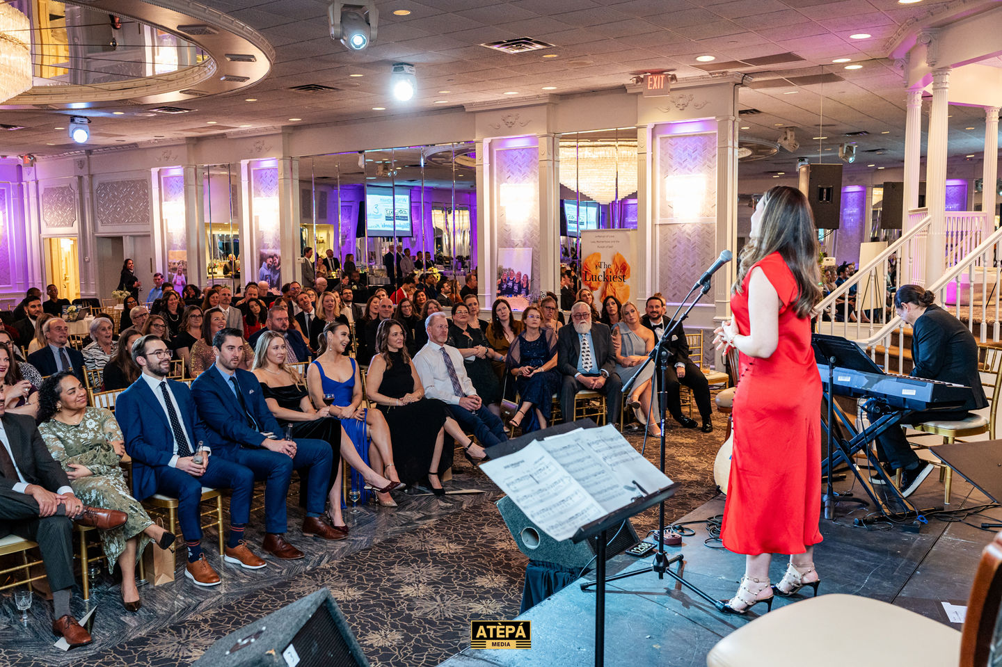 Audience watching a speaker at an indoor event.
