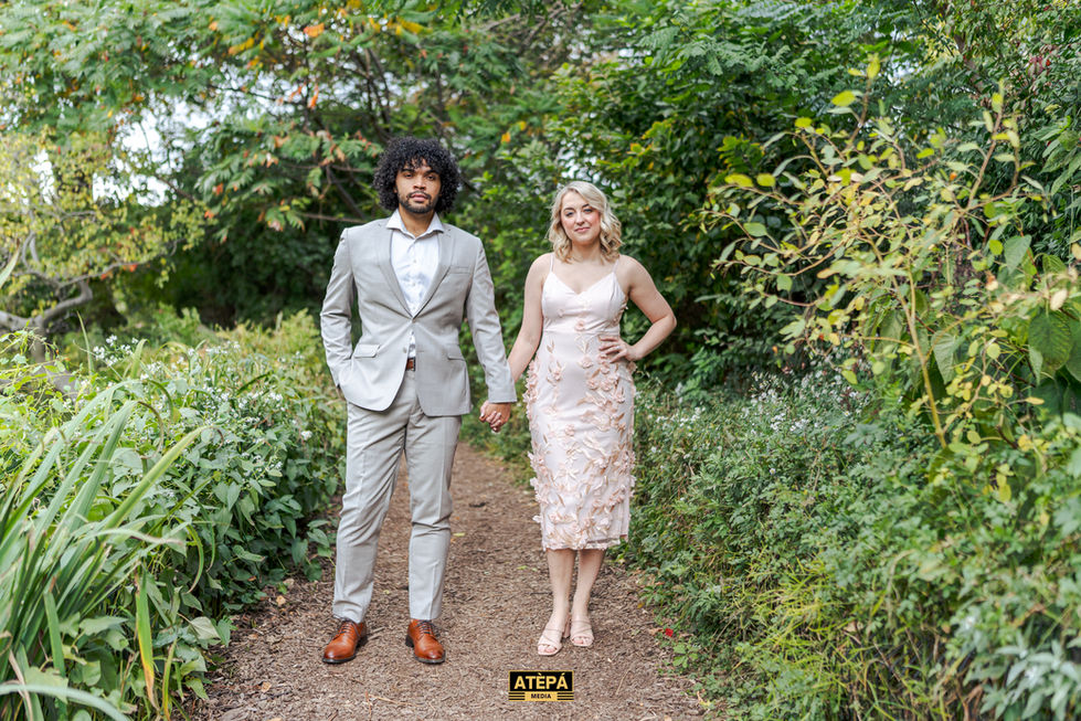 a man in a suit and a woman in a pink dress are holding hands