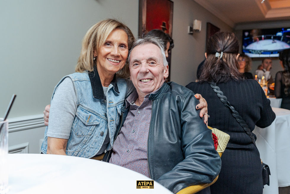 a man and a woman are posing for a picture and the man is wearing a leather jacket