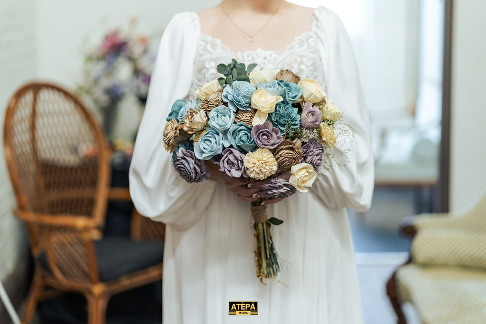 a woman in a white dress is holding a bouquet of wooden flowers from atepa